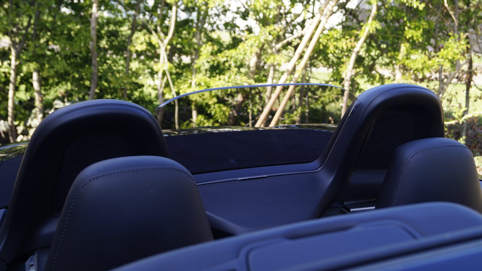 Clear acrylic wind deflector fitted to a Porsche Boxster with the roof down